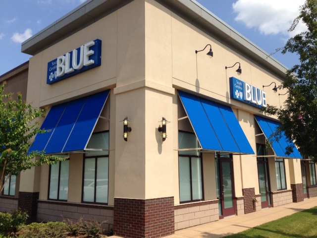 building with blue awnings and blue retail signs